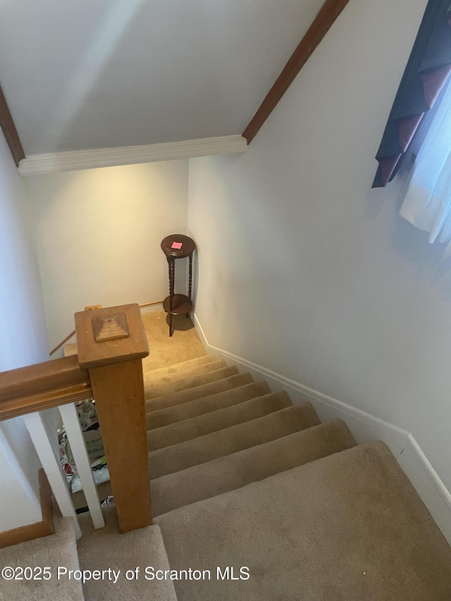 stairway featuring ornamental molding and baseboards