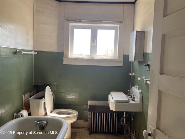 826 N Main St, Forest City, PA 18421 - bathroom with tile walls, radiator heating unit, and a soaking tub