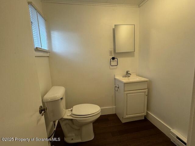 bathroom featuring hardwood / wood-style flooring, vanity, toilet, and crown molding