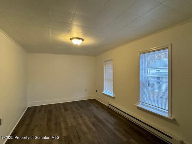 spare room featuring dark hardwood / wood-style flooring and a baseboard radiator