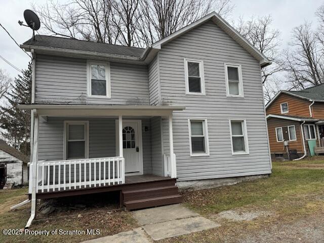 front of property with covered porch and a front lawn