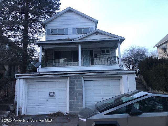 front of property featuring a garage and a balcony