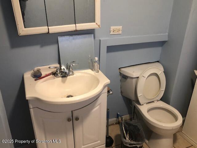 bathroom featuring vanity, tile patterned flooring, and toilet