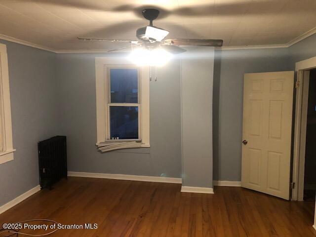 spare room featuring crown molding, ceiling fan, and dark hardwood / wood-style floors