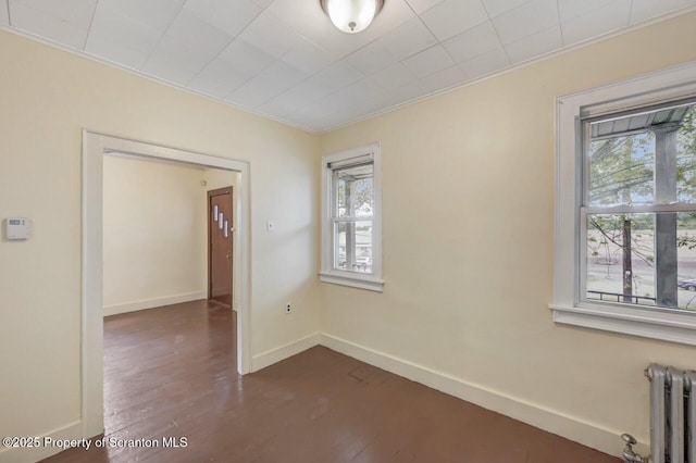 1725 Cedar Ave, Scranton, PA 18505 - empty room featuring radiator, healthy amount of natural light, dark wood finished floors, and ornamental molding