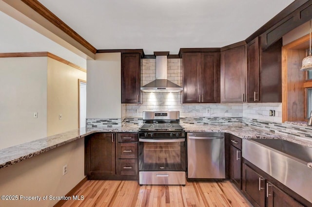 1725 Cedar Ave, Scranton, PA 18505 - kitchen with appliances with stainless steel finishes, wall chimney exhaust hood, light stone countertops, light wood-style floors, and ornamental molding