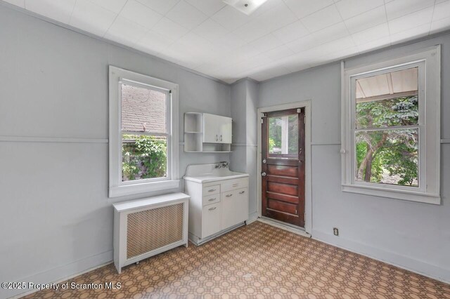 1725 Cedar Ave, Scranton, PA 18505 - kitchen with radiator heating unit, light countertops, white cabinetry, light flooring, and open shelves