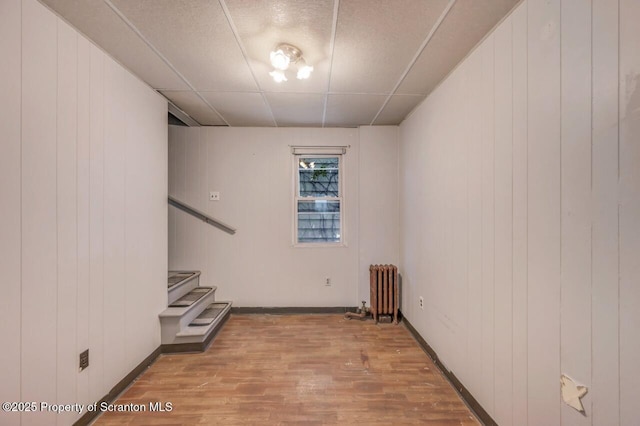 1725 Cedar Ave, Scranton, PA 18505 - unfurnished room featuring radiator, wood finished floors, stairs, and wooden walls