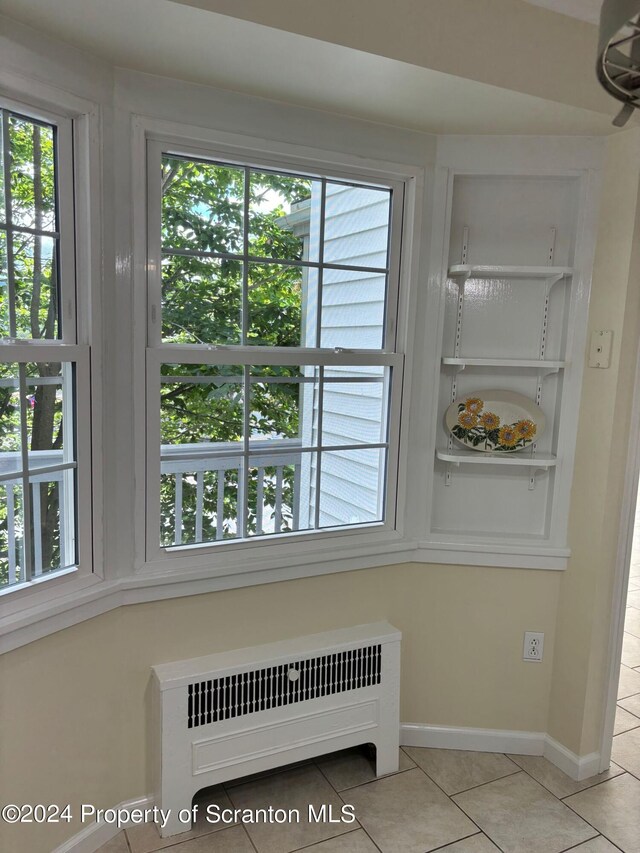 room details with baseboards, ceiling fan, and radiator heating unit