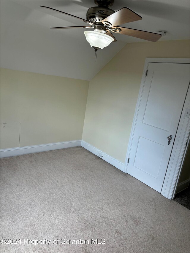 interior space featuring a ceiling fan, baseboards, carpet, and vaulted ceiling