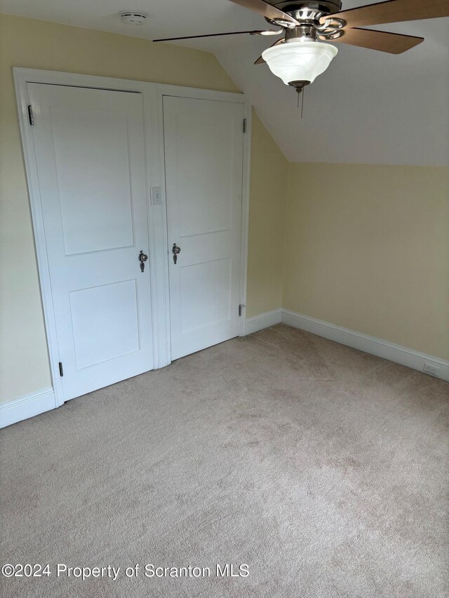 additional living space with baseboards, ceiling fan, lofted ceiling, and light carpet