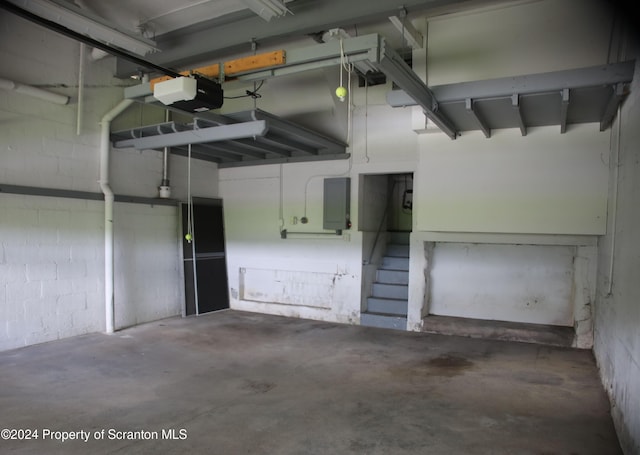 garage with concrete block wall and a garage door opener