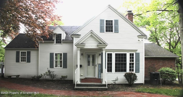 view of front of home with roof with shingles and a chimney