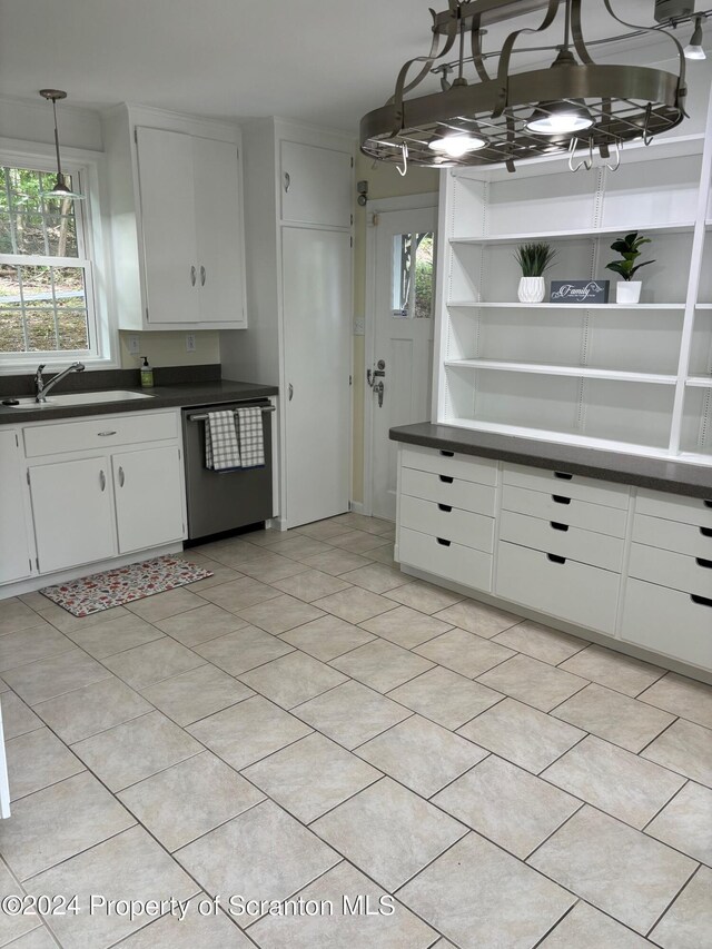 kitchen with a sink, dishwasher, white cabinets, and dark countertops