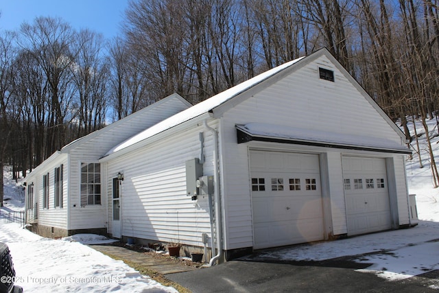 exterior space with a garage and an outbuilding