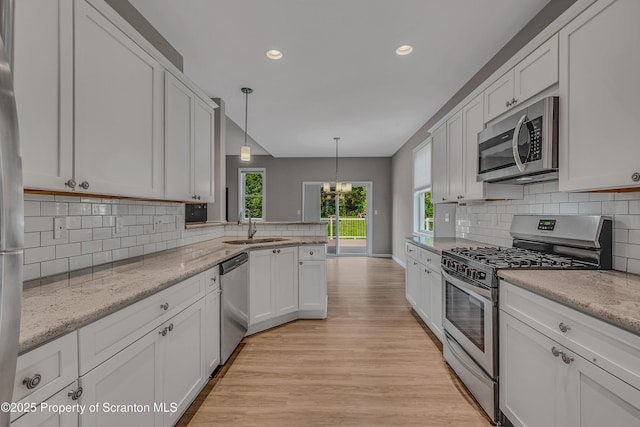 98 Electric St Unit L 1, Clarks Summit, PA 18411 - kitchen featuring appliances with stainless steel finishes, light wood finished floors, decorative backsplash, recessed lighting, and white cabinets