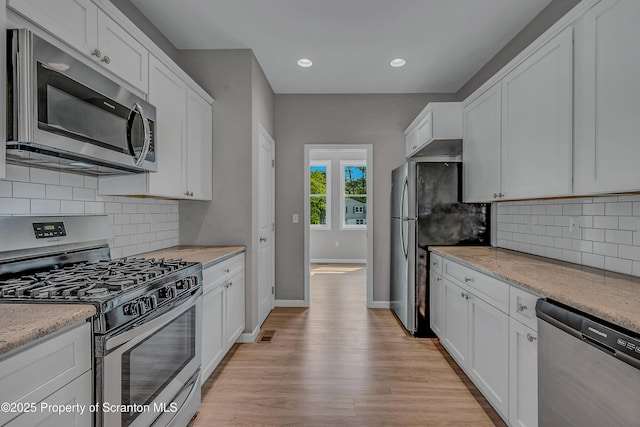 98 Electric St Unit L 1, Clarks Summit, PA 18411 - kitchen featuring appliances with stainless steel finishes, white cabinets, light wood-style floors, decorative backsplash, and recessed lighting