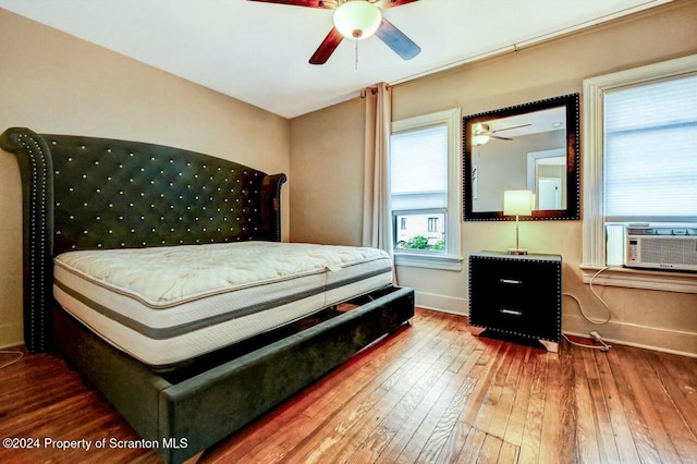 bedroom featuring hardwood / wood-style flooring, ceiling fan, and cooling unit