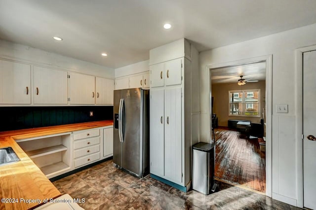 kitchen featuring white cabinets, stainless steel fridge with ice dispenser, built in desk, and ceiling fan