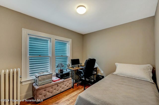 bedroom featuring hardwood / wood-style flooring and radiator