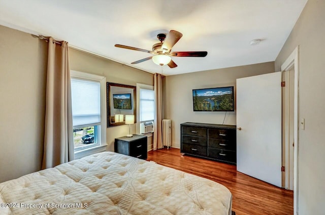 bedroom with radiator, ceiling fan, and dark hardwood / wood-style floors