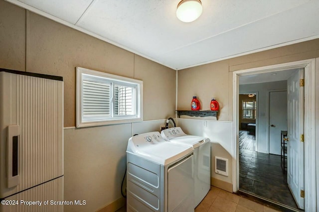 washroom featuring washing machine and dryer and light tile patterned flooring