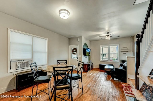 dining area with ceiling fan, hardwood / wood-style floors, and cooling unit