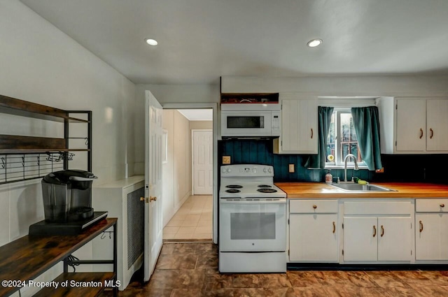 kitchen with white cabinets, white appliances, and sink