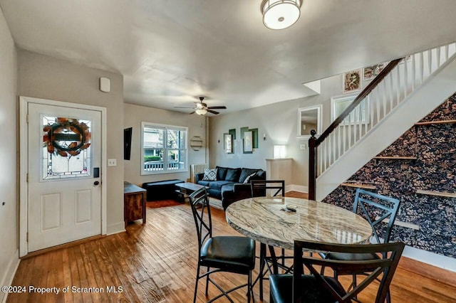 dining space with hardwood / wood-style floors and ceiling fan