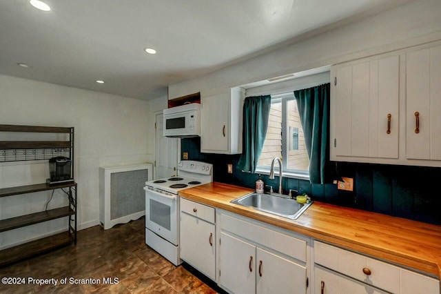 kitchen featuring sink, white cabinets, wooden counters, and white appliances