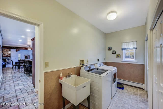 laundry room featuring separate washer and dryer, ceiling fan, sink, and a baseboard heating unit