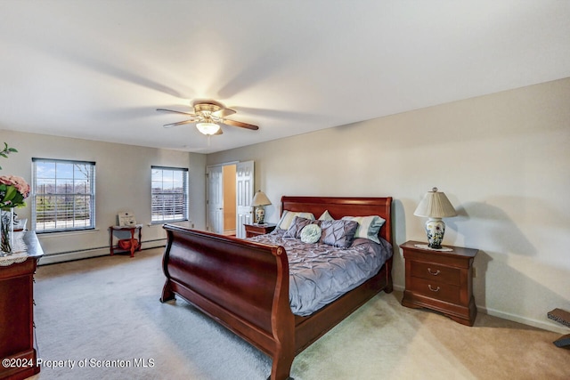 bedroom with light colored carpet, ceiling fan, and a baseboard heating unit