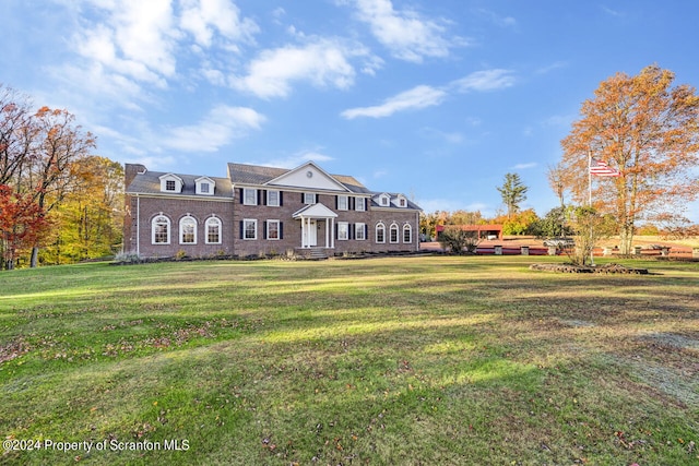 neoclassical home featuring a front lawn