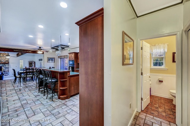 kitchen featuring a breakfast bar, black microwave, and ceiling fan