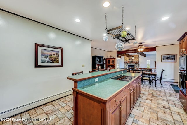 kitchen with a center island, black electric stovetop, a stone fireplace, ceiling fan, and baseboard heating