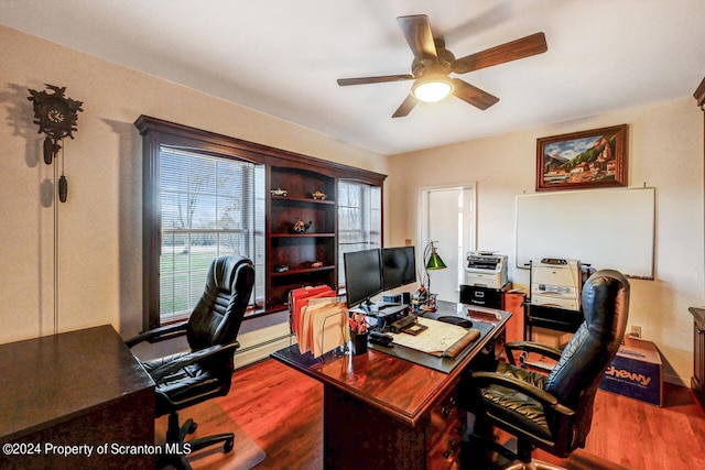 office space with ceiling fan, hardwood / wood-style flooring, and a baseboard heating unit