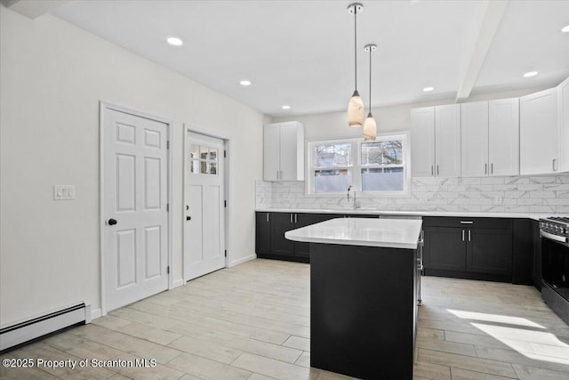 kitchen featuring baseboard heating, light countertops, dark cabinetry, and a sink