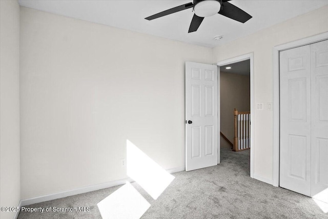 unfurnished bedroom featuring a closet, a ceiling fan, baseboards, and carpet