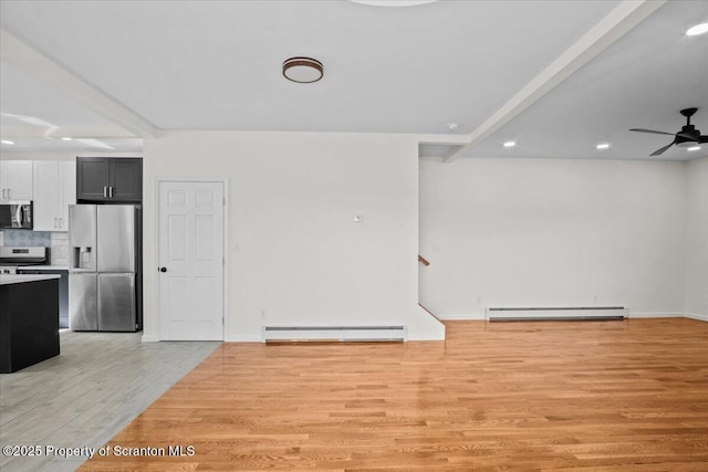 interior space featuring stainless steel appliances, baseboard heating, a baseboard heating unit, light wood-style floors, and open floor plan