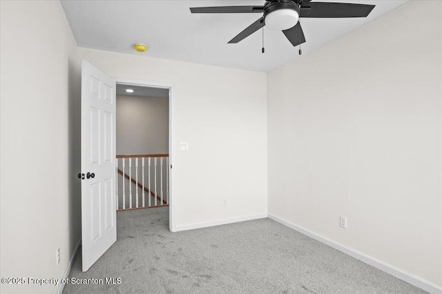 empty room with baseboards, carpet flooring, and a ceiling fan