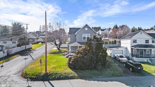 view of front facade with a residential view, driveway, and an attached garage