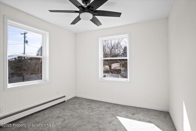 carpeted empty room featuring baseboards, a baseboard heating unit, and a ceiling fan