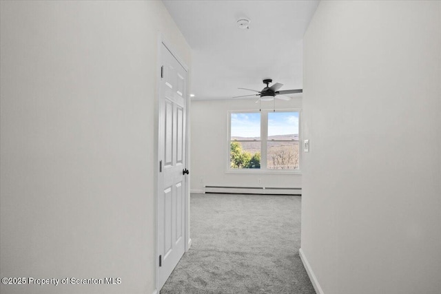 corridor with a baseboard radiator, baseboards, and carpet