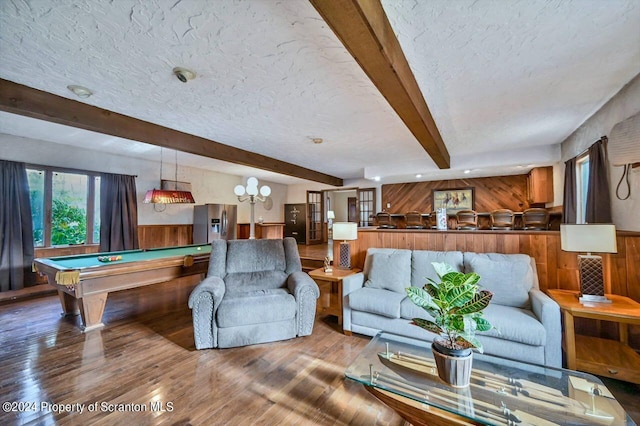 living room featuring beamed ceiling, hardwood / wood-style flooring, wood walls, and pool table