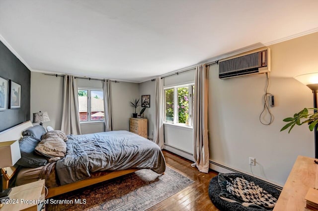 bedroom with baseboard heating, a wall mounted AC, hardwood / wood-style floors, and ornamental molding