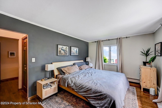 bedroom featuring dark hardwood / wood-style flooring, crown molding, and baseboard heating