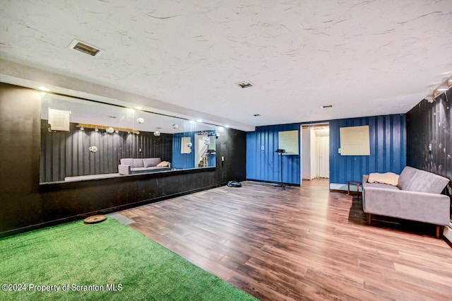 interior space with hardwood / wood-style flooring and wooden walls