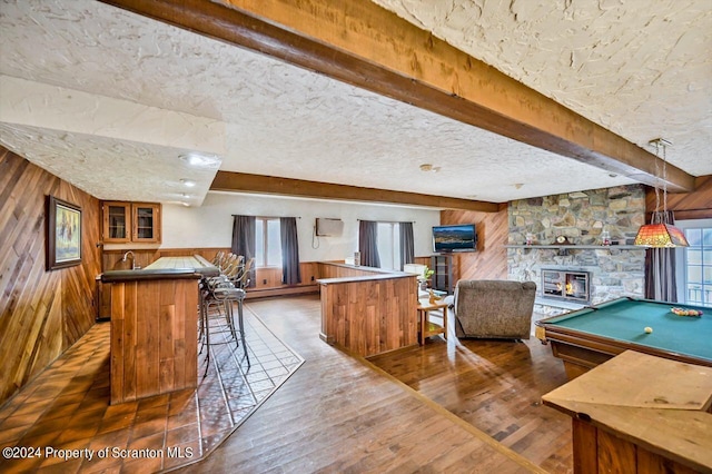 rec room featuring dark hardwood / wood-style flooring, beamed ceiling, billiards, wooden walls, and a fireplace