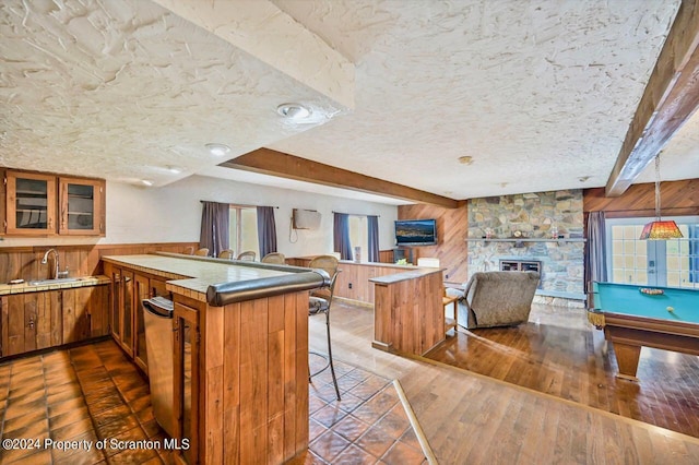 kitchen featuring kitchen peninsula, wood walls, and a breakfast bar