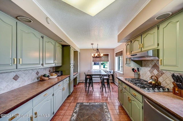 kitchen with backsplash, green cabinets, hanging light fixtures, appliances with stainless steel finishes, and a notable chandelier